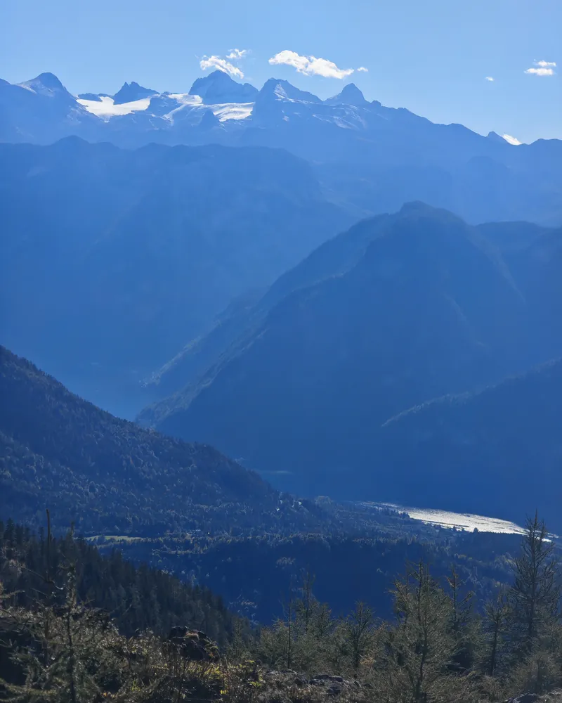 View from the Rehkogl over wooded ridges to Lake Hallstatt and the snow-capped Dachstein massif